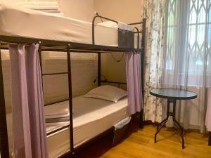 a bedroom with two bunk beds and a table at Hostel 47 in Batumi
