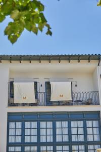 een gebouw met ramen en witte handdoeken op de balkons bij Mon Boutique Hotel in Pollença