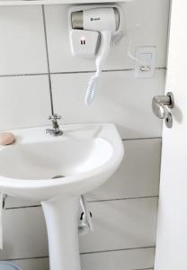 a bathroom with a sink and a phone on the wall at Condomínio Residencial Mar Azul in Imbituba