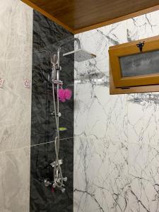 a shower in a bathroom with black and white marble at Zennat bungalov 