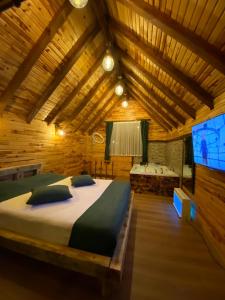 ein Schlafzimmer mit einem großen Bett in einem Holzzimmer in der Unterkunft Zennat bungalov 
