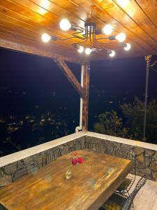 einen Holztisch mit einer Blume auf dem Balkon in der Unterkunft Zennat bungalov 