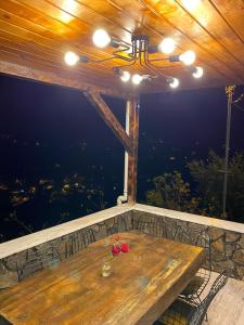 una mesa de madera con una flor en la parte superior de un balcón en Zennat bungalov, 