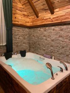 eine Whirlpool-Badewanne in einem Zimmer mit Holzdecke in der Unterkunft Zennat bungalov 