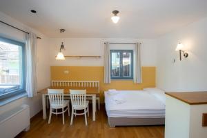 una camera con letto, tavolo e sedie di Lakeside Apartments Bled a Bled