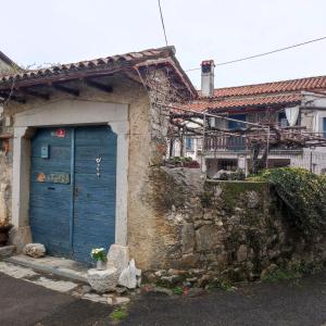 una puerta azul en el lateral de una casa en Apartma Hiša Pliska, en Pliskovica