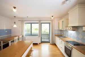 a kitchen with white cabinets and a large window at Lakeside Apartments Bled in Bled