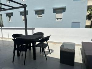 un tavolo nero e sedie sul balcone di Gorgeous 1-Bedroom Beachside Suite a San Juan