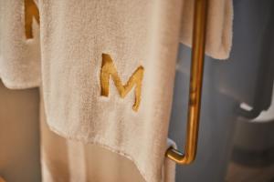 een handdoek met de letter n erop hangend aan een rek bij Mon Boutique Hotel in Pollença