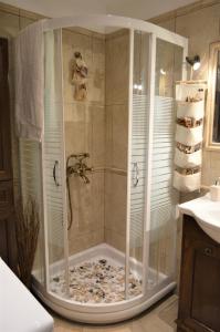 a bathroom with a shower with rocks in it at Heraklia's house in Perama