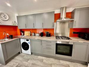 a kitchen with white cabinets and a stove top oven at Paintworks View by MyCityHaven in Bristol