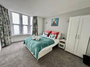 1 dormitorio con 1 cama con almohadas rojas en Paintworks View by MyCityHaven, en Bristol