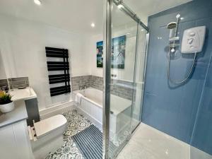 a bathroom with a shower and a toilet and a tub at Paintworks View by MyCityHaven in Bristol