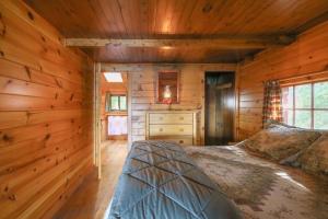 1 dormitorio con 1 cama en una cabaña de madera en Attean Lake Lodge, en Jackman