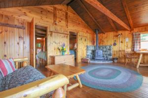salon z kominkiem w drewnianym domku w obiekcie Attean Lake Lodge w mieście Jackman