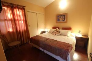 a bedroom with a bed and a chair and a window at Ventanas al cerro recargado! in La Rioja