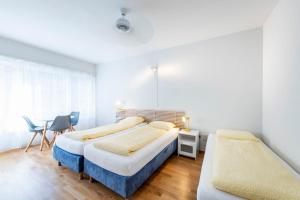 - une chambre avec 2 lits, une table et des chaises dans l'établissement Hotel Atlantico, à Lugano