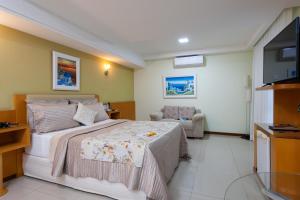 a hotel room with a bed and a television at Hotel Santorini in Vila Velha