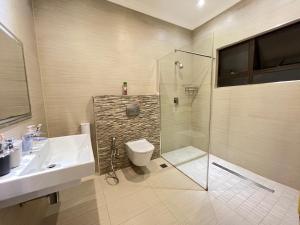 a bathroom with a shower and a sink and a toilet at La Vue in Port Shepstone