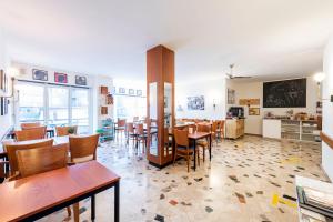 une salle à manger avec des tables et des chaises ainsi qu'une salle de classe dans l'établissement Hotel Atlantico, à Lugano