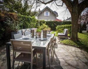 una mesa de comedor y sillas en un patio en Venez Chez Vous - Villa Magnolia, en Annecy