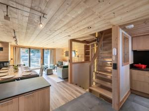 eine Küche und ein Wohnzimmer mit einer Treppe in einem winzigen Haus in der Unterkunft Chalet moderne à Méribel avec 5 chambres, sauna et accès rapide aux pistes - FR-1-566-45 in Les Allues