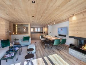 ein Esszimmer und ein Wohnzimmer mit Kamin in der Unterkunft Chalet moderne à Méribel avec 5 chambres, sauna et accès rapide aux pistes - FR-1-566-45 in Les Allues