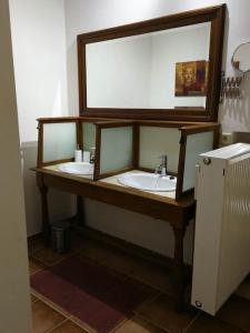 baño con lavabo y espejo grande en La sittelle des aguesses en Andenne