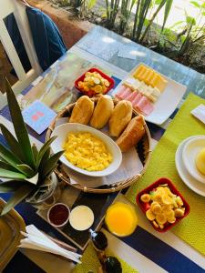a table with a plate of breakfast food on it at Pousada Tropicana in Abraão
