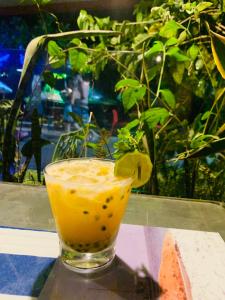 a drink sitting on a table next to a plant at Pousada Tropicana in Abraão