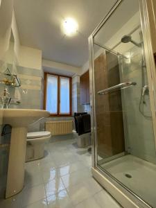 een badkamer met een douche, een wastafel en een toilet bij Cortazzis 6 in Udine