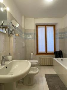 een badkamer met een wastafel, een bad en een toilet bij Cortazzis 6 in Udine