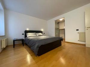 een slaapkamer met een groot bed en een houten vloer bij Cortazzis 6 in Udine