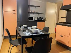a kitchen with a table and chairs in a kitchen at Cortazzis 6 in Udine