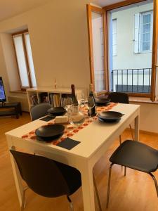 een eettafel met stoelen en een witte tafel met glazen bij Cortazzis 6 in Udine