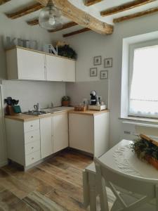 a kitchen with white cabinets and a table and a window at Il Cavallo a Dondolo in Abbadia San Salvatore