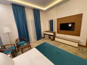 a hotel room with a bed and a flat screen tv at Golden Jewel Ismailia Resort in Ismailia