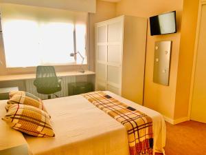 a bedroom with a bed and a tv on the wall at Family & Groups Space, Santiago Center - No Kitchen in Santiago de Compostela