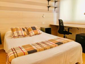 a bedroom with a bed with pillows and a chair at Family & Groups Space, Santiago Center - No Kitchen in Santiago de Compostela
