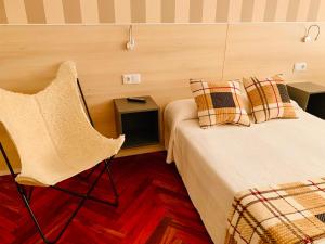 a room with two beds and a chair in it at Family & Groups Space, Santiago Center - No Kitchen in Santiago de Compostela