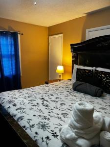 a bedroom with a bed with a black and white blanket at #2BR Cozy Villa - Mins to Historic STM Amusement Park! in Stone Mountain