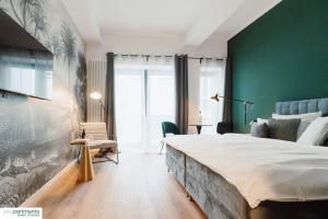a bedroom with a large bed and a green wall at City-Studio mit Boxspring-Bett und Küche in Münster
