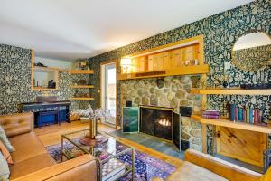 sala de estar con chimenea y pared de piedra en Lake George Oasis with 9 Acres, Hot Tub and Game Room!, en Diamond Point