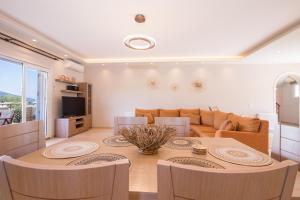 a kitchen and living room with a table and chairs at VILLA ALEXANDRA in Dassia