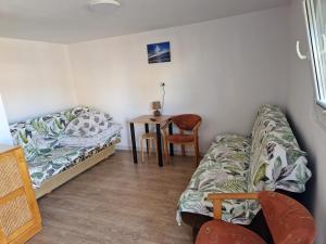 um quarto com uma cama e uma mesa com uma cadeira em Kwatery u Beaty em Krynica Morska - Piaski
