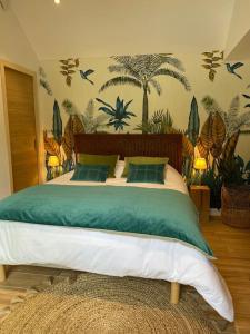 a bedroom with a bed with green and white sheets at LE CLOS DAUPHINAIS Chez Laurette in Quévert