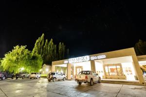 马拉圭马拉格酒店的一家商店,晚上有汽车停在停车场