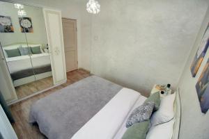 ein Schlafzimmer mit einem Bett und einem großen Spiegel in der Unterkunft Уютная квартира в ЖК Адиет с видом на горы in Almaty