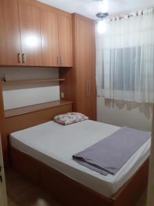 um pequeno quarto com uma cama e uma janela em Chácara com Piscina em Araçoiaba da Serra