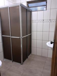 a bathroom with a shower and a toilet and a sink at Chácara com Piscina in Araçoiaba da Serra